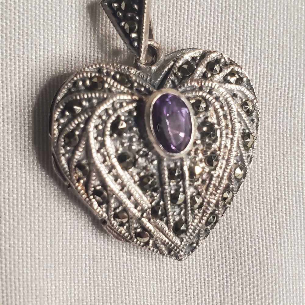 Sterling silver heart locket features a marcasite filigree design Purple Stone